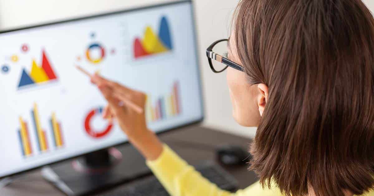 Image of a woman studying data visualization graphs of different colors and shapes.